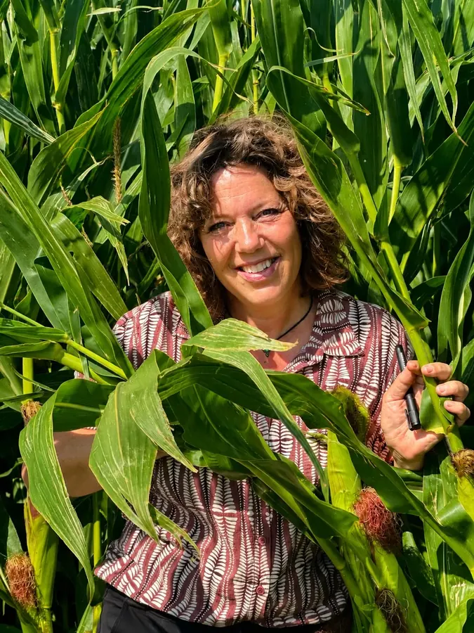 Monique Slok van Een Bundel Geluk lachend tussen de maisplanten, oprichter van het atelier in Enkhuizen